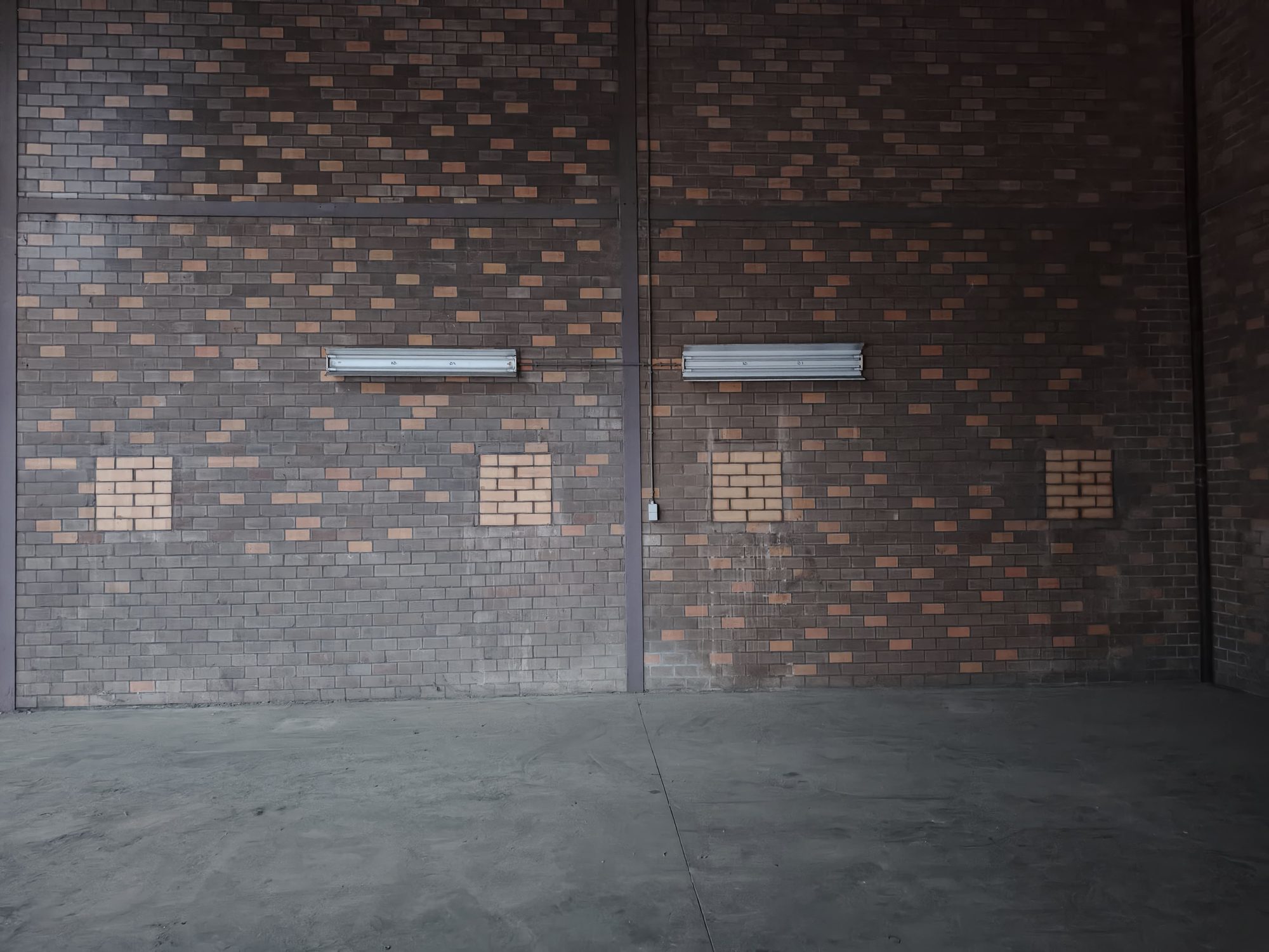 Dichtgemetselde garagepoort en ramen in de wand van een bedrijfshal