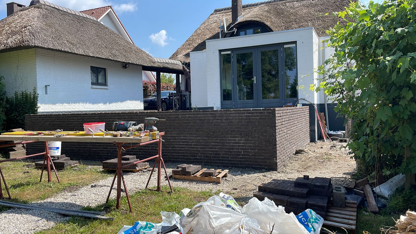 Gemetselde terrasmuur in donkere gevelsteen bij een woning