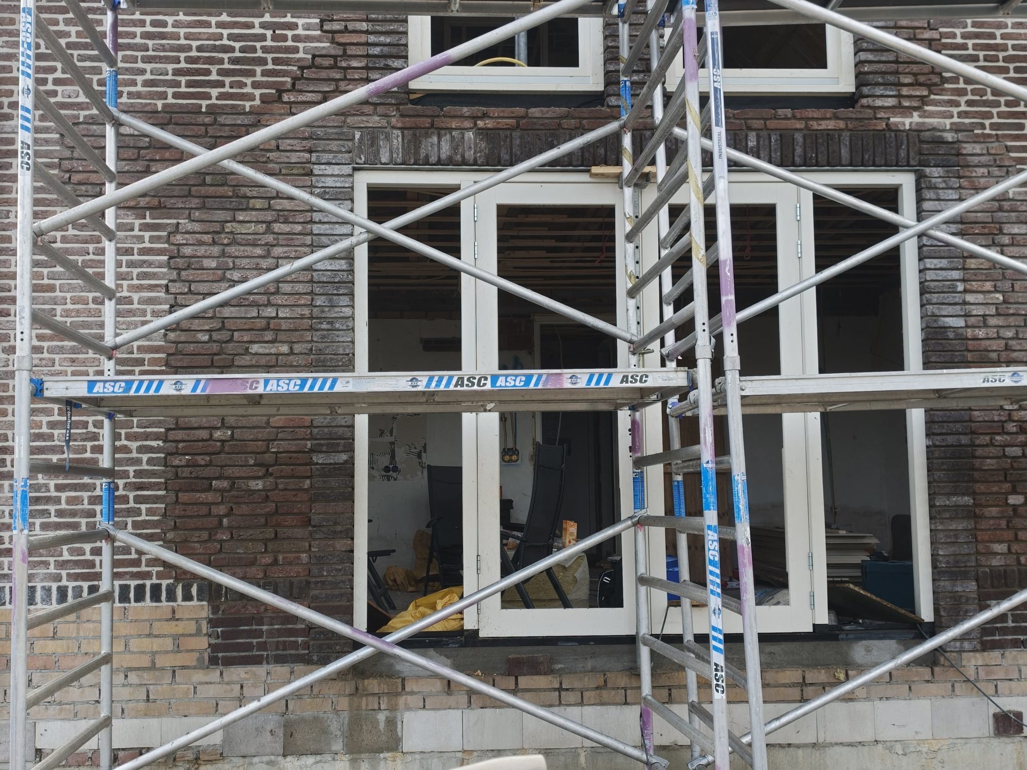 Gerenoveerde gevel met nieuwe kozijnen en netjes aangesloten metselwerk