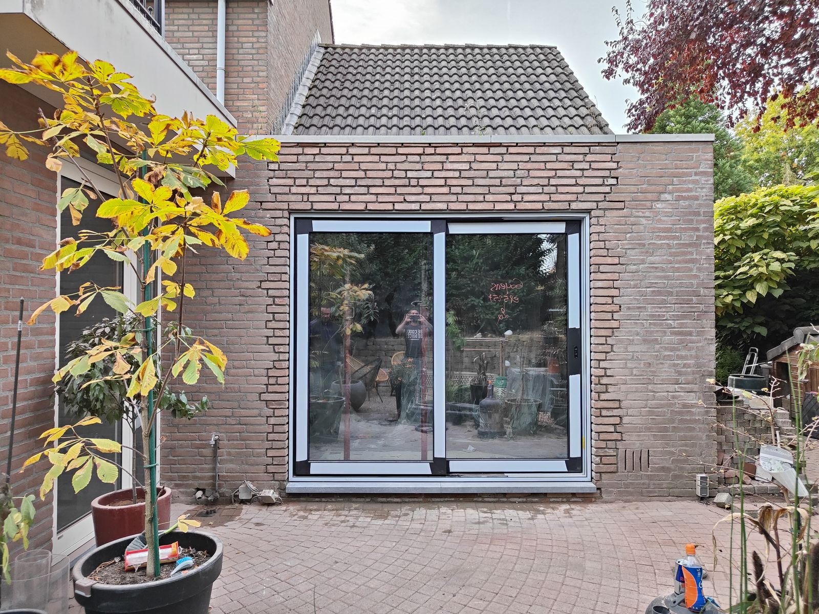 Nieuwe gevel in gevelsteen met brede schuifpui aan de tuinzijde