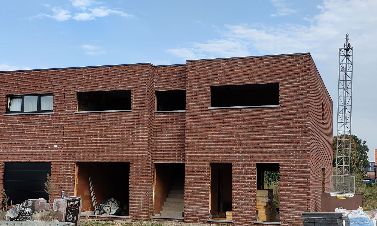 Voorgevel van een nieuwbouw met plat dak in rode gevelsteen